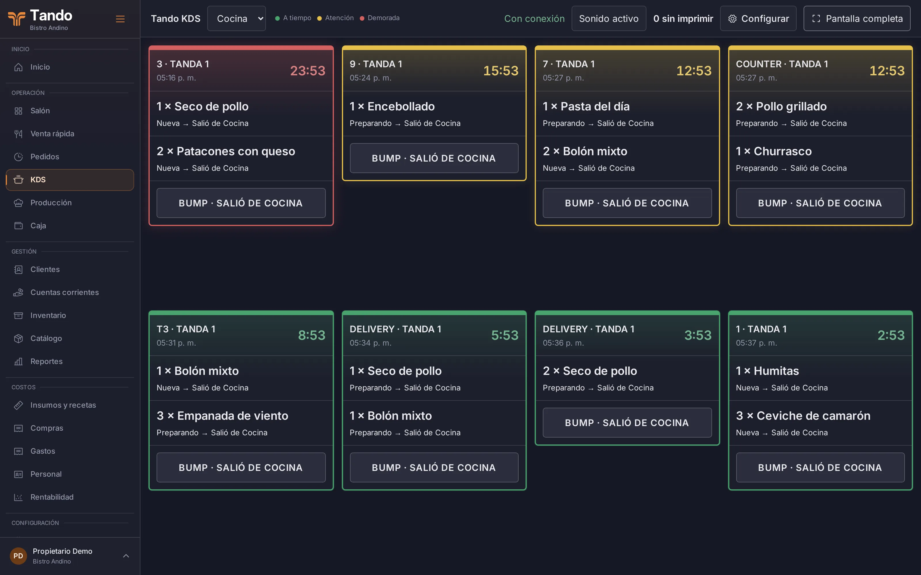 Pantalla de cocina con comandas por tanda. La primera, en rojo, lleva 23 minutos; la segunda, en amarillo, 15 minutos.